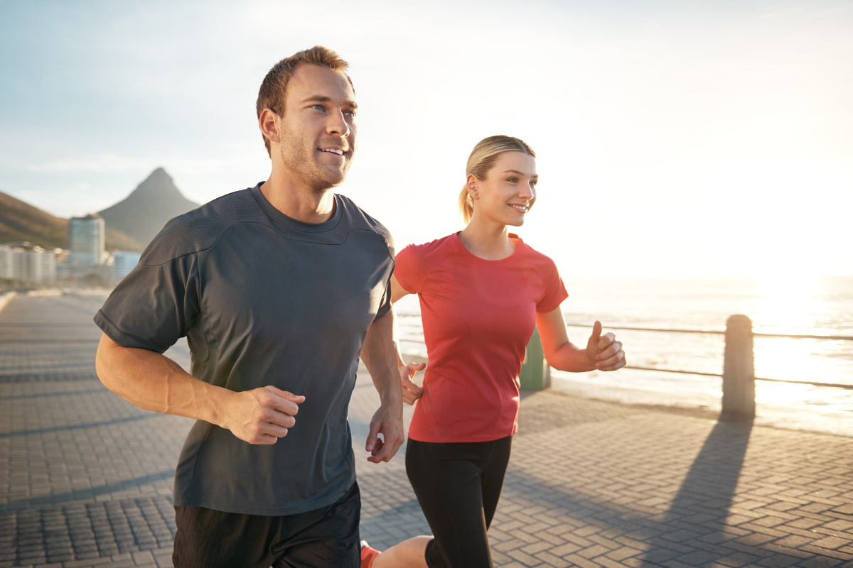 couple exercising together by the beach