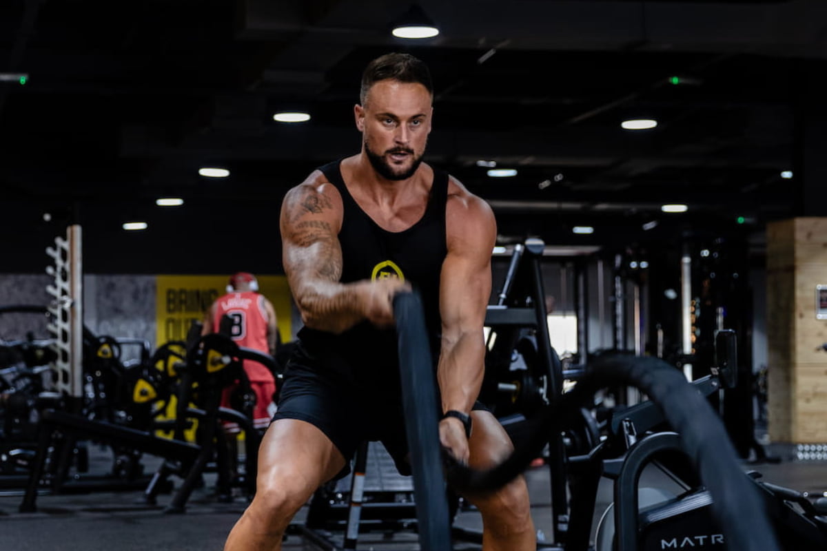 Fitness expert using the battle ropes in the gym