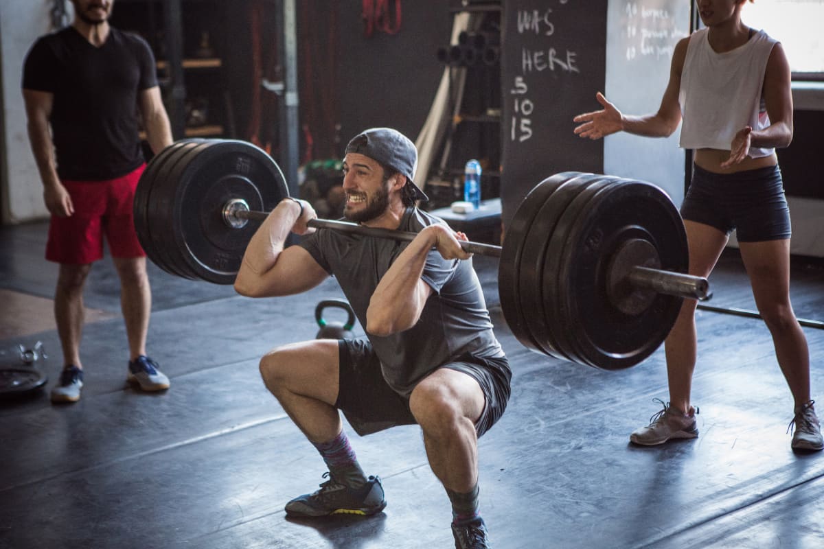 Man exercising int he gym performing a loaded front squat